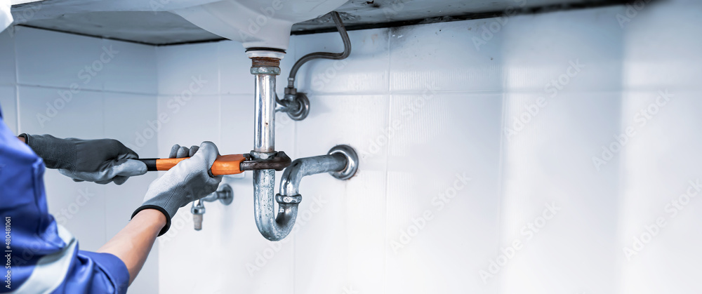 Plumber fixing drain pipes